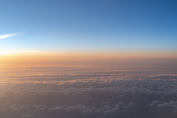 Vue de l'horizon du ciel bleu foncé au lever du soleil, dans les airs. vue depuis une fenêtre d'avion
 - Photo, image