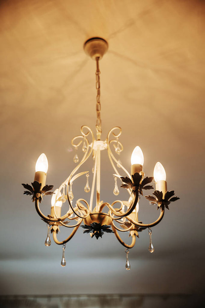 Лампа из блэк-металла и хрустальной люстры на потолке
. - Фото, изображение