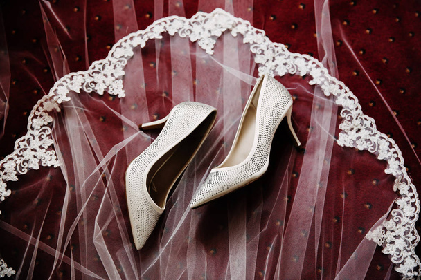 Λευκό γάμο γυναικεία παπούτσια τοποθετημένα σε ένα φόντο λευκό πέπλο. - Φωτογραφία, εικόνα