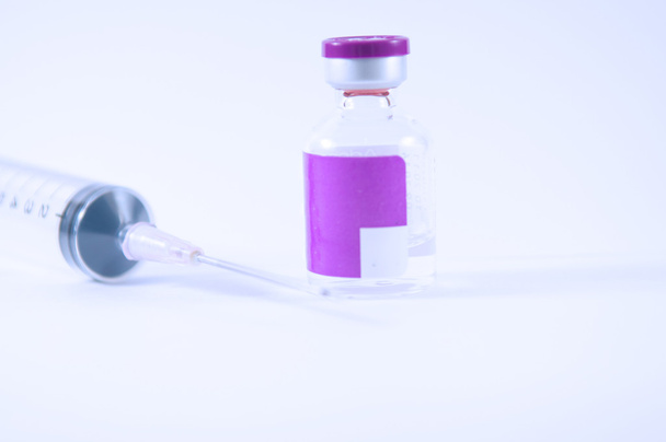 Ampolla de etiqueta púrpura y suringe desechable
 - Foto, Imagen