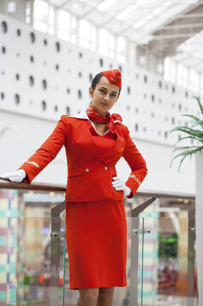 RUSSIA, MOSCOW: 28 JUNE 2019. Beautiful stewardess dressed in official red uniform of Aeroflot Airlines on airport - Fotó, kép