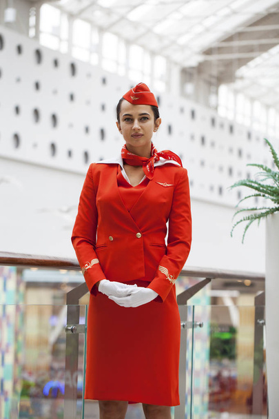 RUSSIA, MOSCOW: 28 JUNE 2019. Beautiful stewardess dressed in official red uniform of Aeroflot Airlines on airport - Photo, Image