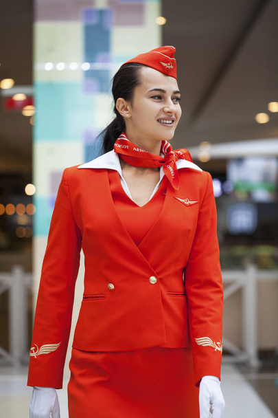 RUSSIA, MOSCOW: 28 JUNE 2019. Beautiful stewardess dressed in official red uniform of Aeroflot Airlines on airport - Foto, afbeelding
