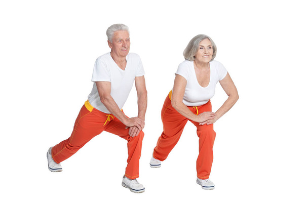 Portrait of Senior couple exercising on white background - Фото, зображення