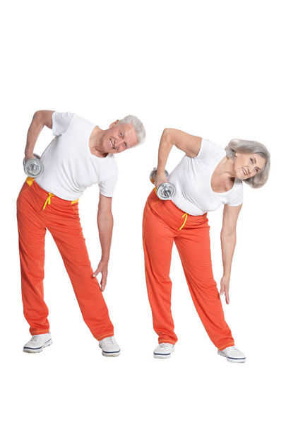 Portrait of Senior couple exercising on white background - Фото, зображення