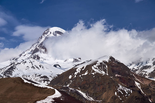 Kazbek bergtop in de wolken. - Foto, afbeelding
