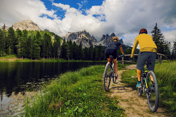 ciclismo mujer y hombre a caballo en bicicletas en las montañas Dolomitas y
 - Foto, Imagen