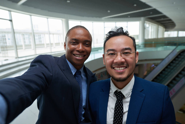 fröhlich freundliche multiethnische Geschäftsleute, die zusammen fotografieren - Foto, Bild