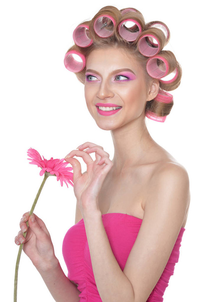 portrait of beautiful woman with hair curlers  holding flower isolated on white  - Photo, Image