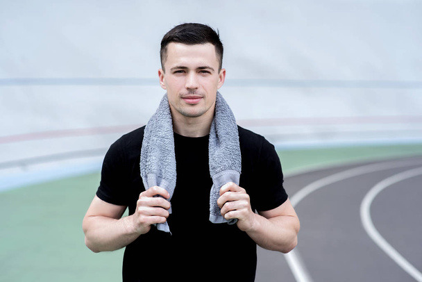 handsome sportsman with towel standing on stadium  - Photo, Image
