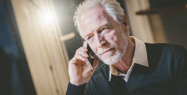 Portret van senior moderne man praten op mobiele telefoon - Foto, afbeelding