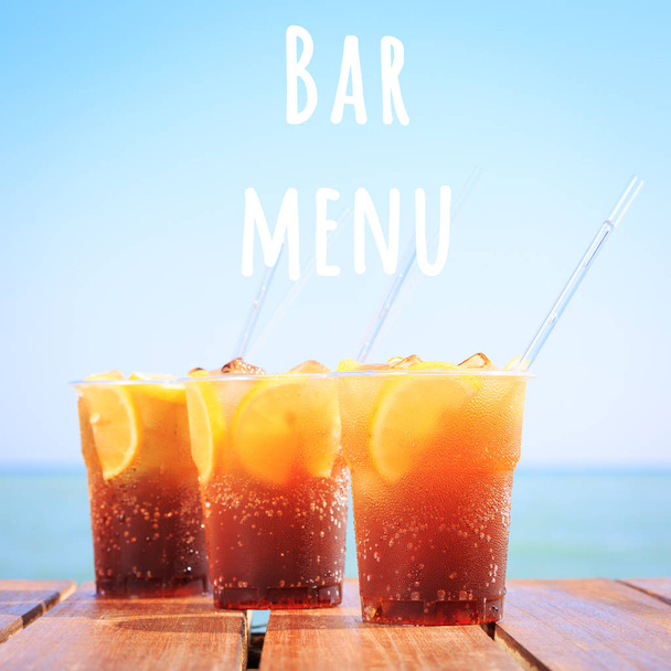 Concept van luxe tropische vakantie. Drie Cuba Libre cocktails op de pier. Balk menu formulering - Foto, afbeelding