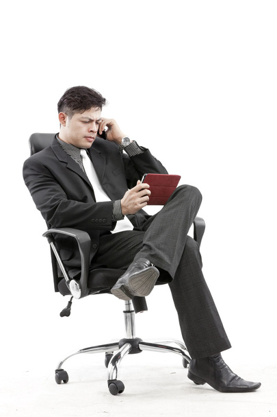 Portrait of a businessman sitting with digital tablet - Foto, afbeelding