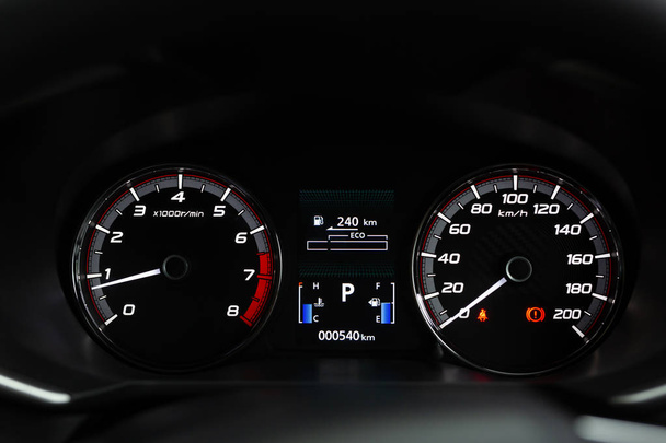Close-up moderne kilometerstand auto dashboard instrumentenpaneel interieur met waarschuwingslampjes, veiligheidsgordels en handrem verlichting. Miles snelheidsmeter - Foto, afbeelding