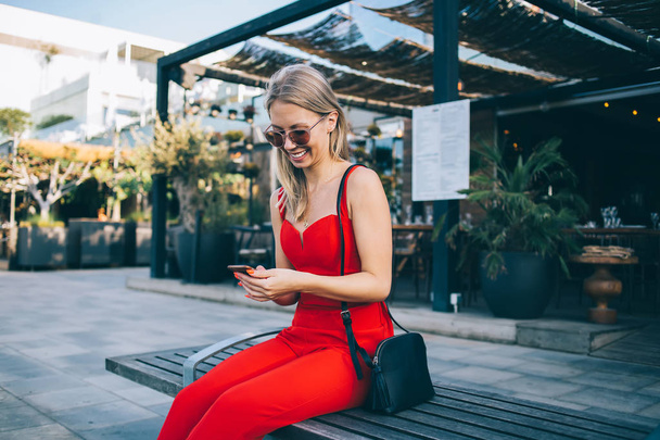 Stylish modern woman with phone on bench - Foto, Bild