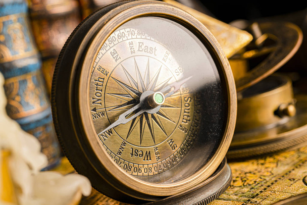 Antique compass on the background of the globe and books. Vintag - 写真・画像