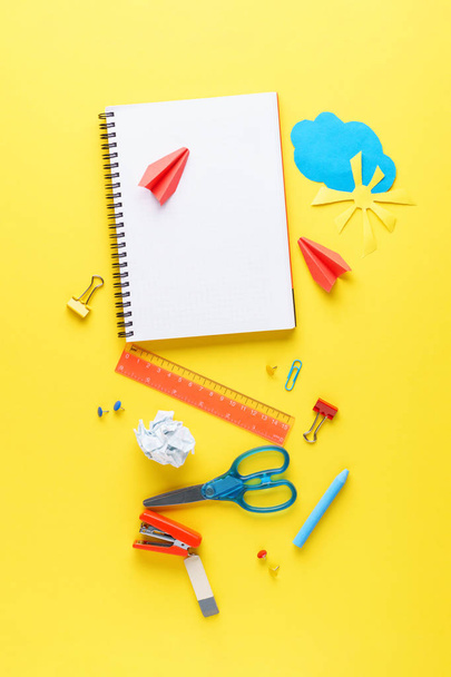 Bunch of various colorful stationery on yellow background. - Foto, afbeelding