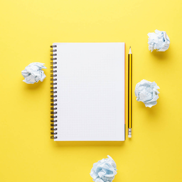 Open notebook, pencil and crumpled papers on yellow background. - Foto, Imagen