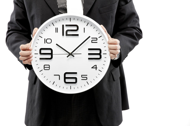 Portrait of a businessman holding a clock against white background - Fotografie, Obrázek