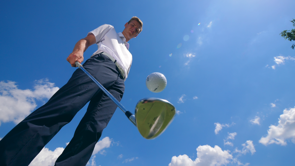 Miespelaaja jongleeraa golfpalloa.
 - Materiaali, video