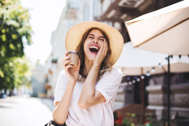 Emotional woman having expression and laughing because of funny story. She walking street in summer mood and she happy because of her holiday time - 写真・画像