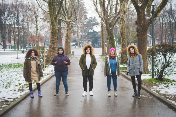 grupo de mujeres jóvenes multirraciales posando en avenida arbolada
  - Foto, imagen