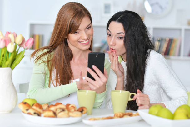two female friends with modern smartphone - Foto, afbeelding