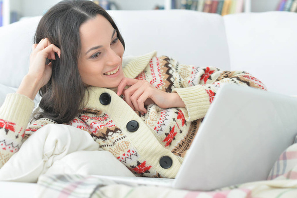 young beautiful woman  with laptop on sofa  at home - Foto, afbeelding