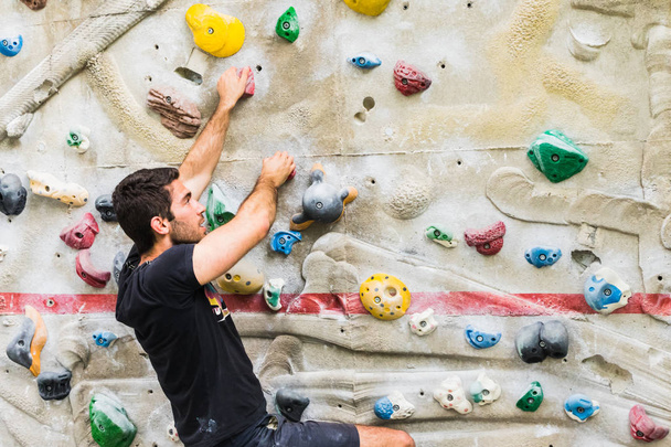 Man practicing rock climbing on artificial wall indoors. Active  - Fotoğraf, Görsel