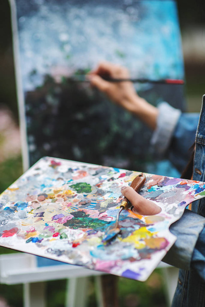 Kunst, creativiteit en mensen concept-close-up van kunstenaar met palet en borstel schilderij stilleven op papier in Studio outdoor. Afbeelding van veld bloemen - Foto, afbeelding