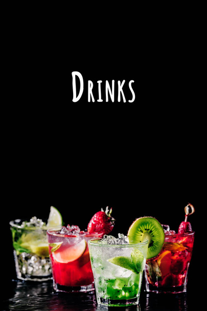 Cztery kolorowe smaczne koktajle alkoholowe z rzędu w barze stoiska. Brzmienie napojów - Zdjęcie, obraz