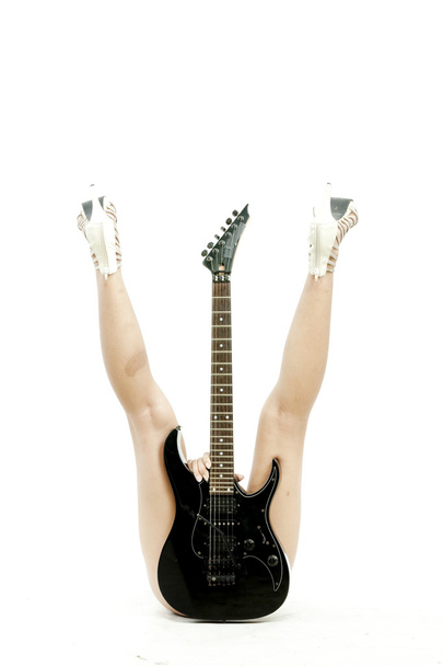 Picture of laying woman holding guitar in front of her and between the legs over white background - Zdjęcie, obraz