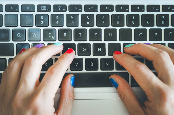 Home Office oder Online-Shopping: Frauenfinger mit buntem Nagel - Foto, Bild