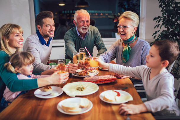 Famille multi-génération appréciant les repas autour de la table à la maison
 - Photo, image