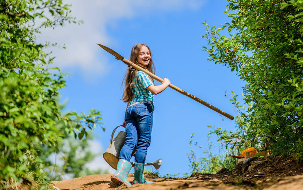 future success. small girl on rancho. summer farming. farmer small girl. garden tools, shovel and watering can. kid worker sunny outdoor. family bonding. spring country side village. Flowers expert - Fotoğraf, Görsel