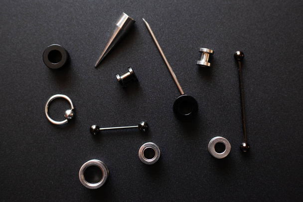 Piercing-Accessoires auf schwarzem Hintergrund Edelmetall-Schmuck für Pannenliebhaber - Foto, Bild