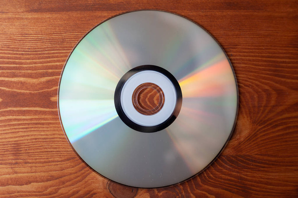 CD Compact Disc na jasnym drewnianym tle widok z góry  - Zdjęcie, obraz