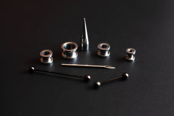 akcesoria piercing na czarnym tle biżuteria ze stali nierdzewnej dla miłośników przebicia - Zdjęcie, obraz
