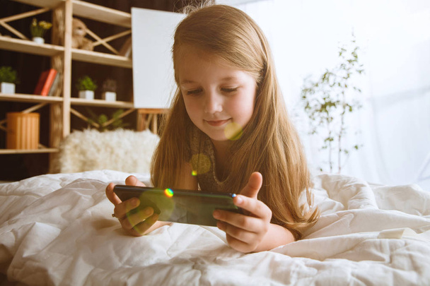 Little girl using different gadgets at home - Foto, Bild