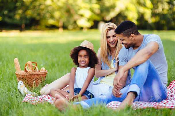 Picture of lovely couple with their daughter having picnic in nature - Foto, Bild