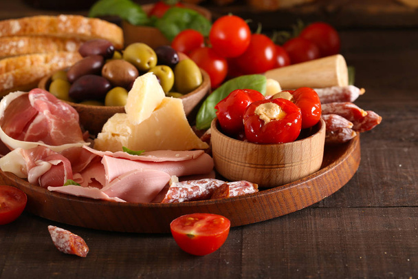 Italiaans eten, prosciutto, olijven, kaas en tomaten - Foto, afbeelding