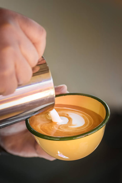 Hands of barista making cappuccino coffee pouring milk on espresso. - Foto, Imagen