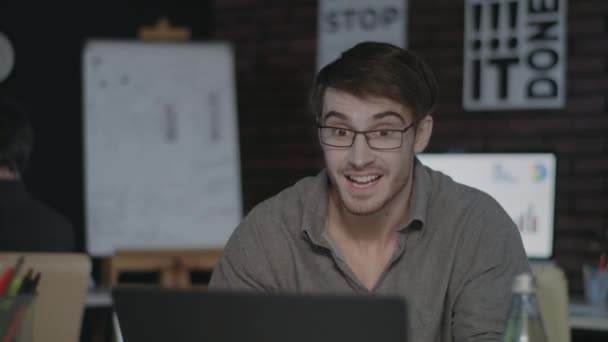 Joyful zakenman op zoek naar laptop scherm en het doen van ja gebaar in donker kantoor - Video