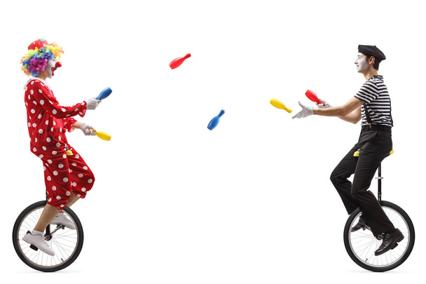 Mime and clown on unicycles juggling with clubs - 写真・画像