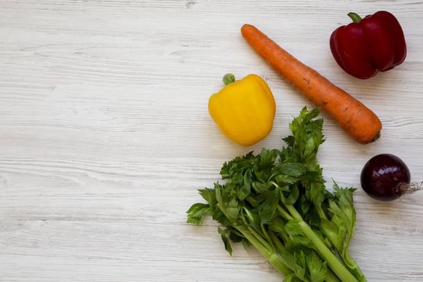 frisches Gemüse (Karotten, Sellerie, Zwiebeln, farbige Paprika) auf einem - Foto, Bild