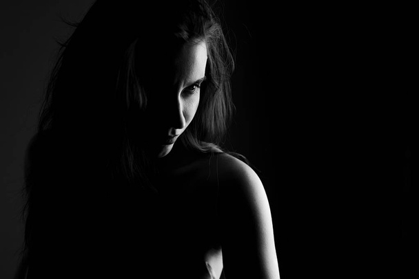 Portrait of a girl in black and white on black background in noir style - Photo, image