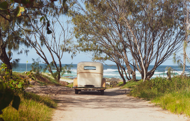 Luxusní automobil zaparkovaný v přístupu na pláž s výhledem na moře zezadu - Fotografie, Obrázek