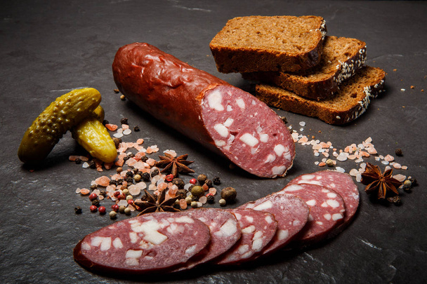 köstliche trockene Salamiwurst mit Roggenbrot und eingelegten Gurken - Foto, Bild