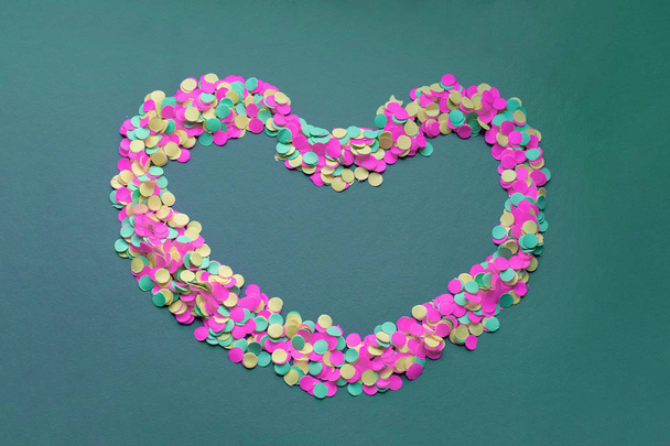 Colorful confetti in the shape of a heart on a dark background - Photo, Image