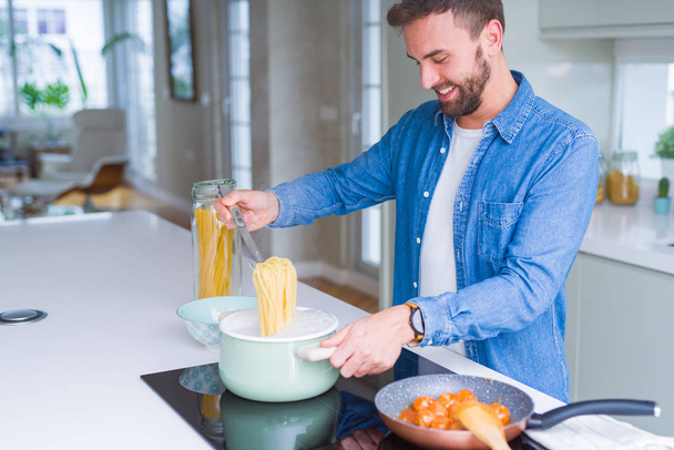 Bell'uomo che cucina la pasta a casa - Foto, immagini